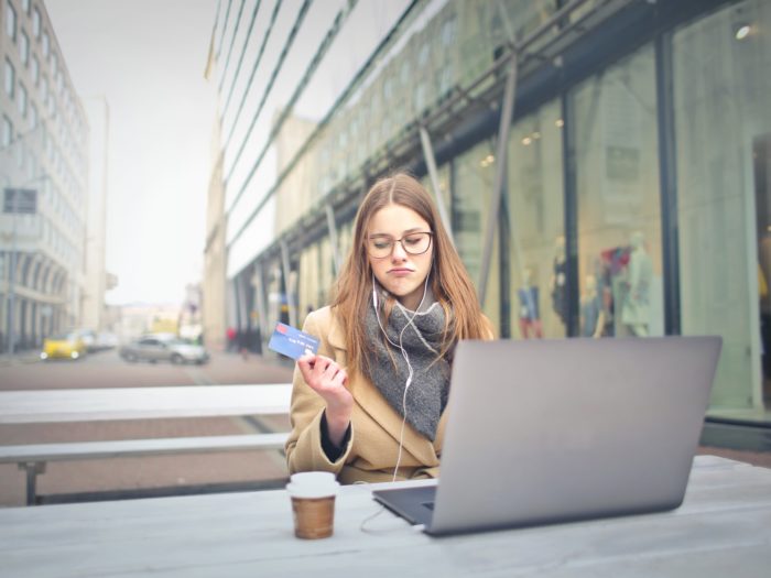 woman-in-brown-coat-holding-a-bank-card-3784391