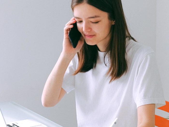 woman-in-white-crew-neck-t-shirt-holding-black-smartphone-3987028