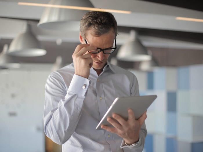 man-reading-an-article-on-tablet-3760096