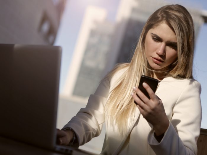 woman-in-white-blazer-holding-black-smartphone-3781558